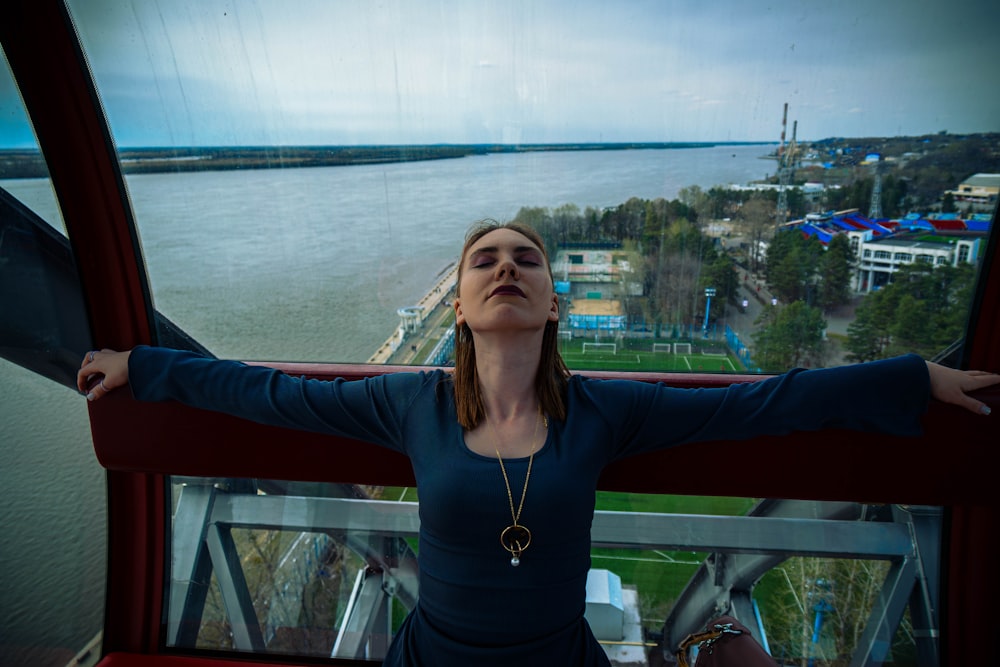 a woman standing on top of a tower next to a body of water