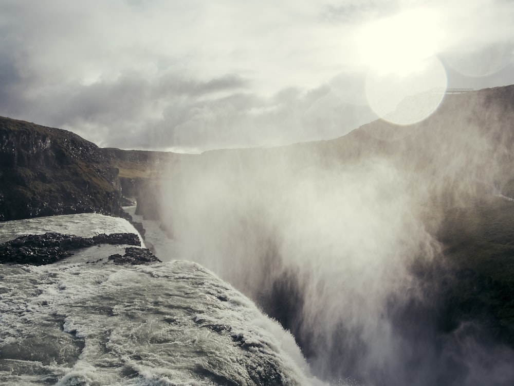 a view of a waterfall in the middle of a mountain