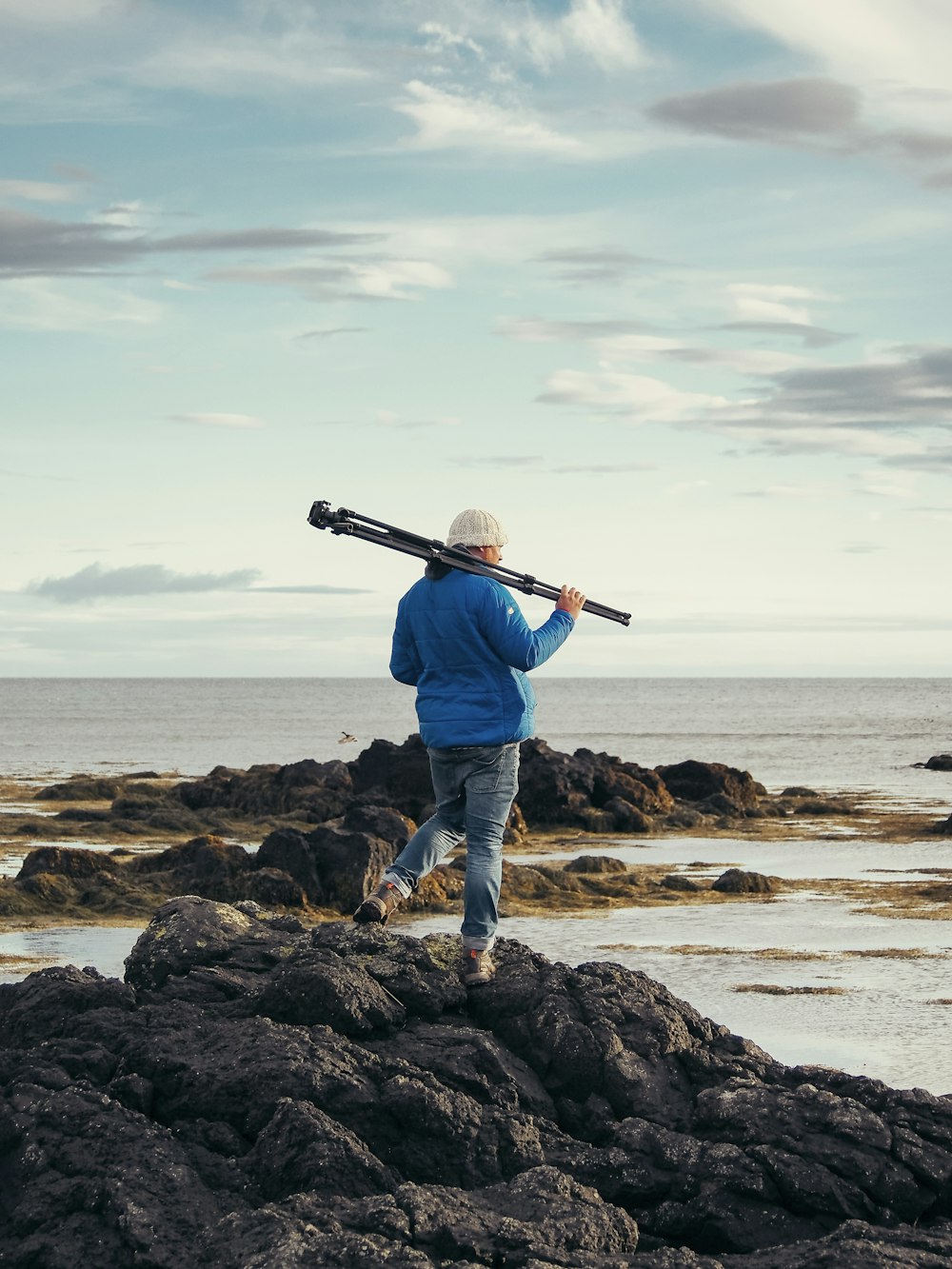 a man with a baseball bat on a rocky beach