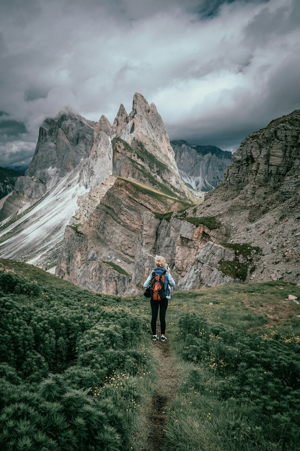 a person with a backpack walking up a trail in the mountains