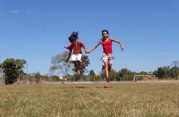 a couple of people that are running in the grass