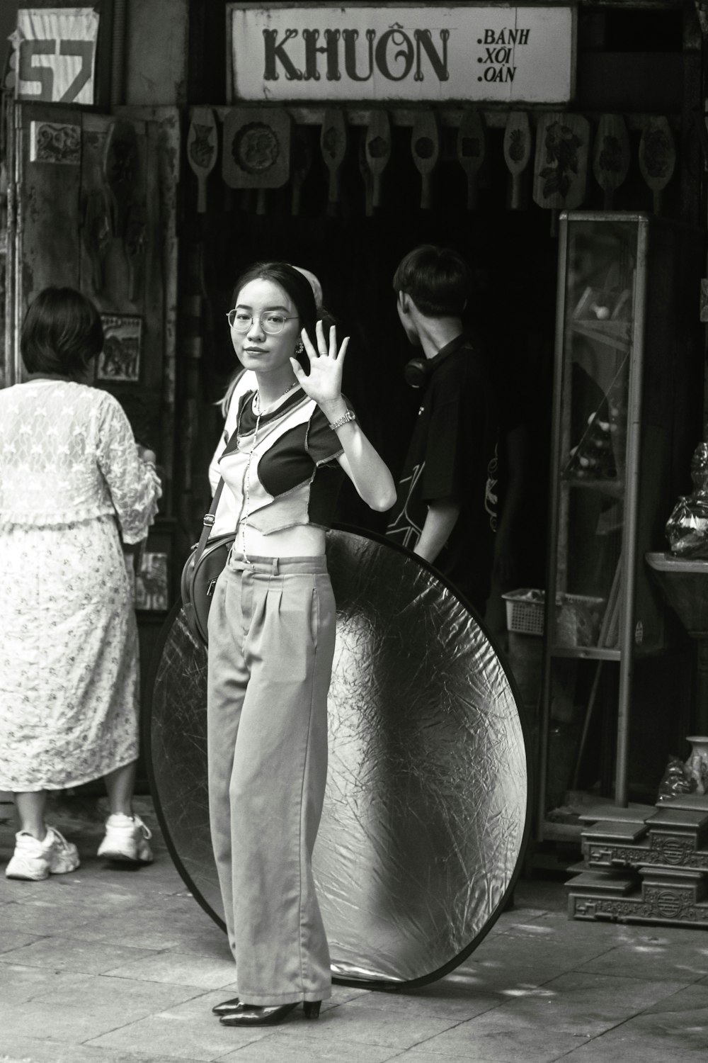 a black and white photo of a woman holding a large object