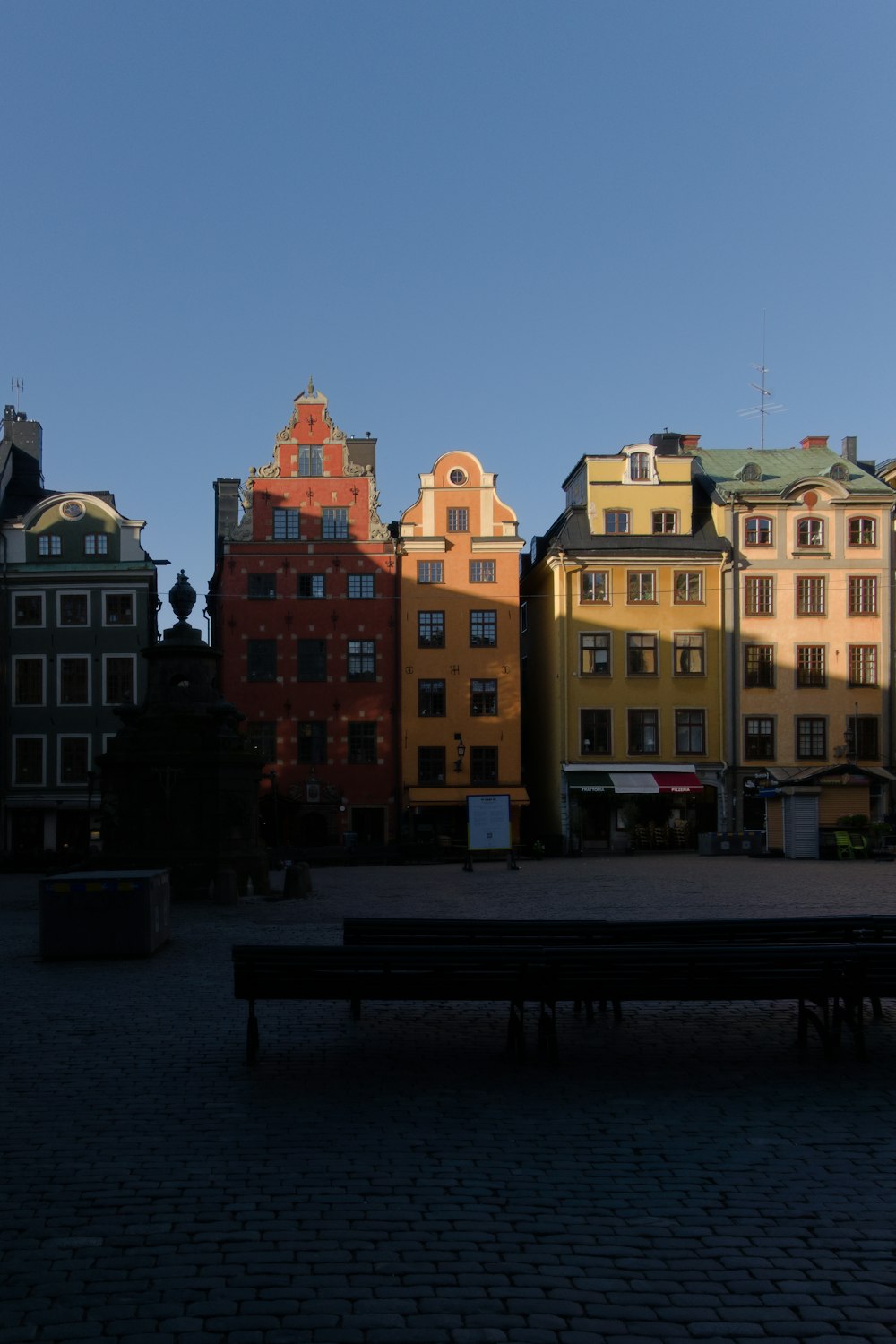 Un banco sentado frente a una hilera de edificios