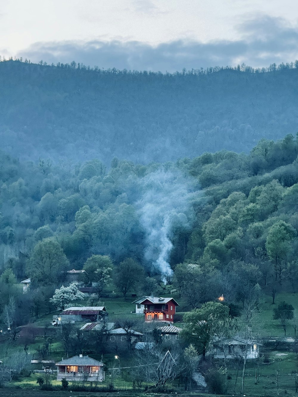 煙がたくさん出ている丘の上の家