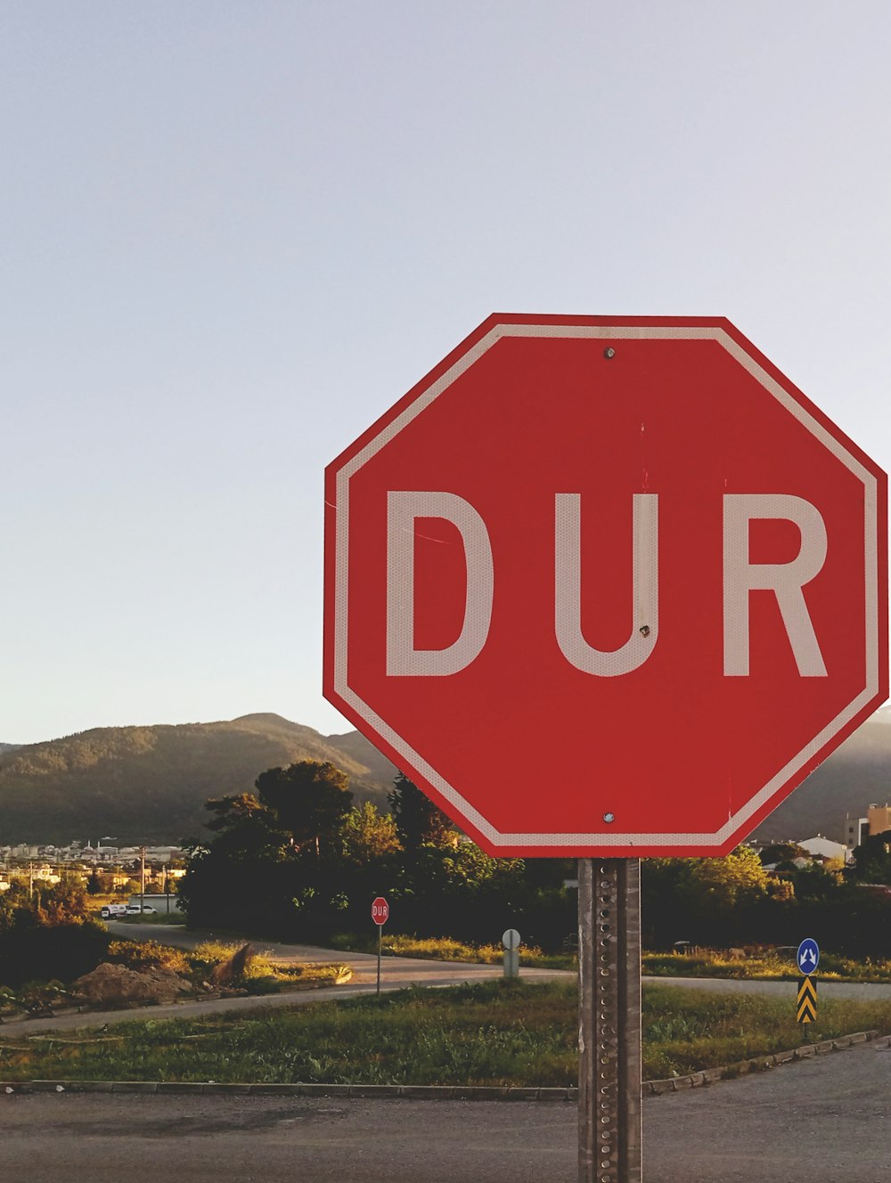 a red stop sign sitting on the side of a road