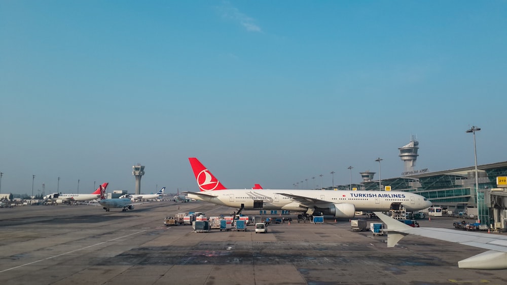 a group of airplanes parked at an airport