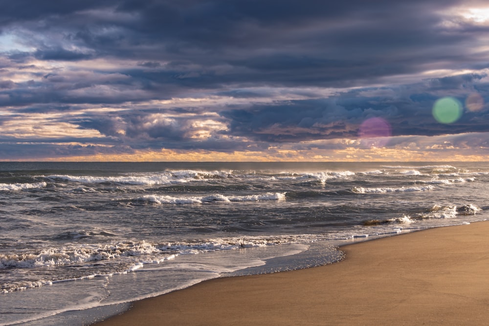 a sandy beach with waves coming in to shore