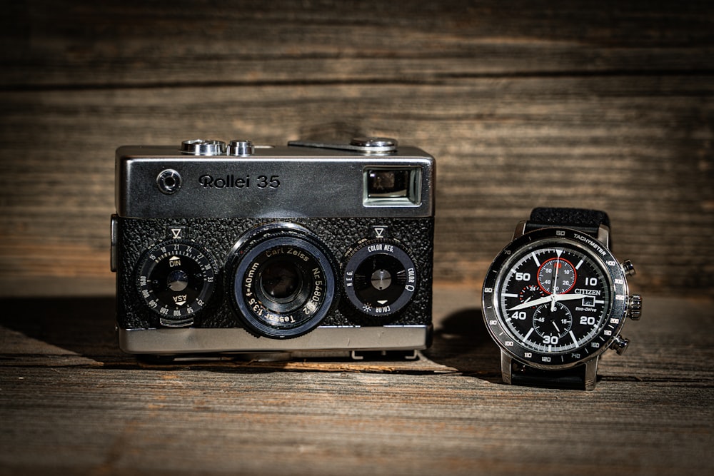 a watch and a camera sitting on a table
