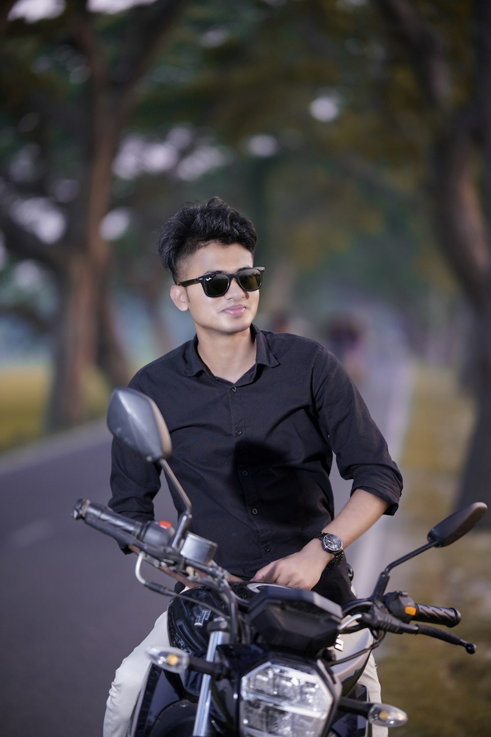 a man wearing sunglasses standing next to a motorcycle