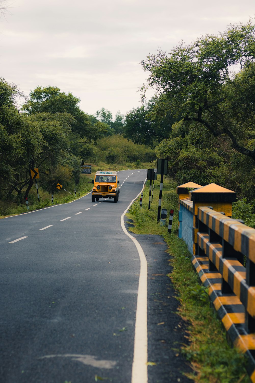 a yellow school bus driving down a rural road