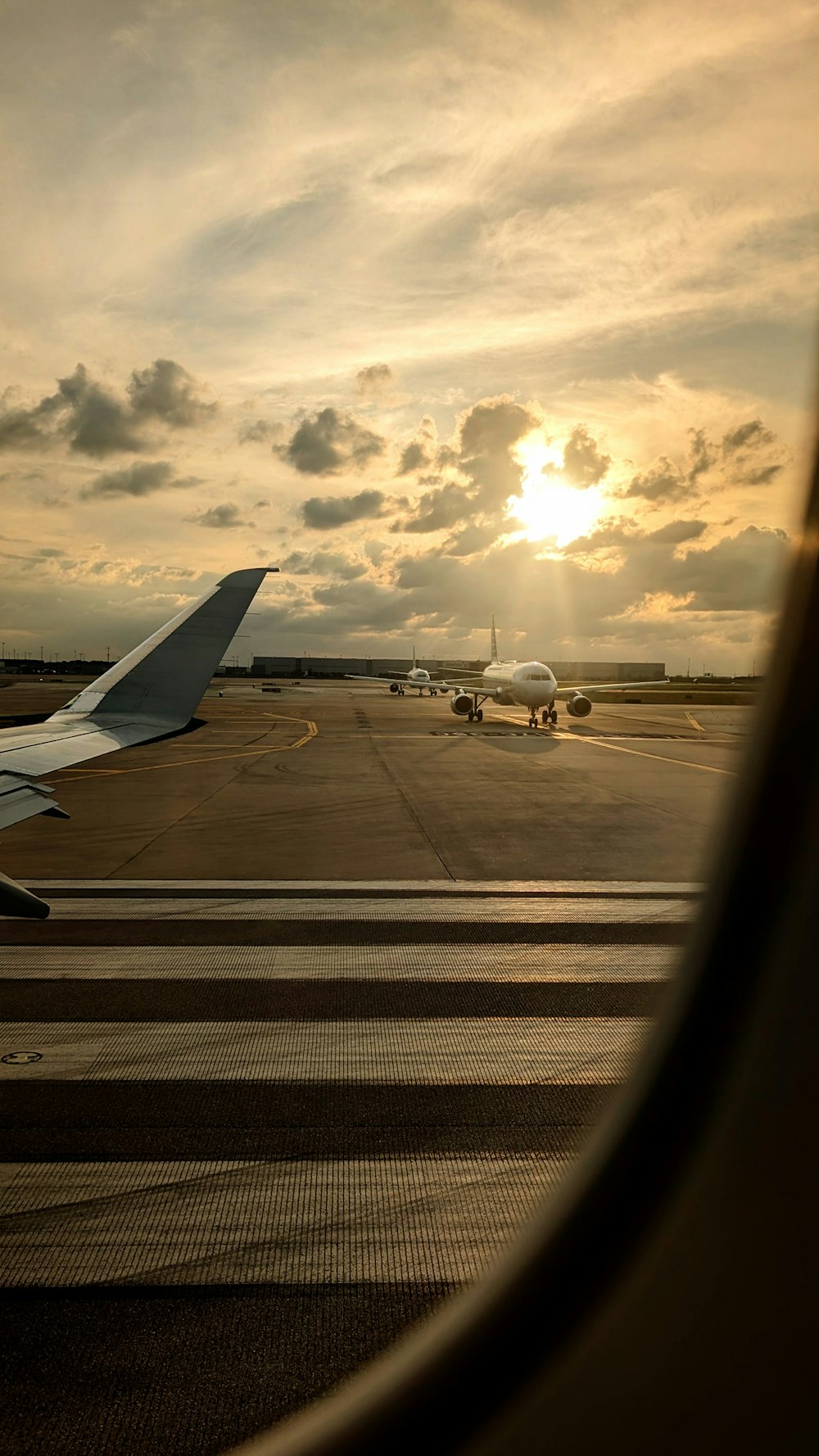 a view of the wing of an airplane as the sun sets