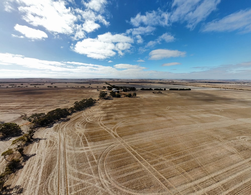 an aerial view of a farm field with a blue sky in the background