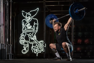 a man squatting with a barbell in his hands