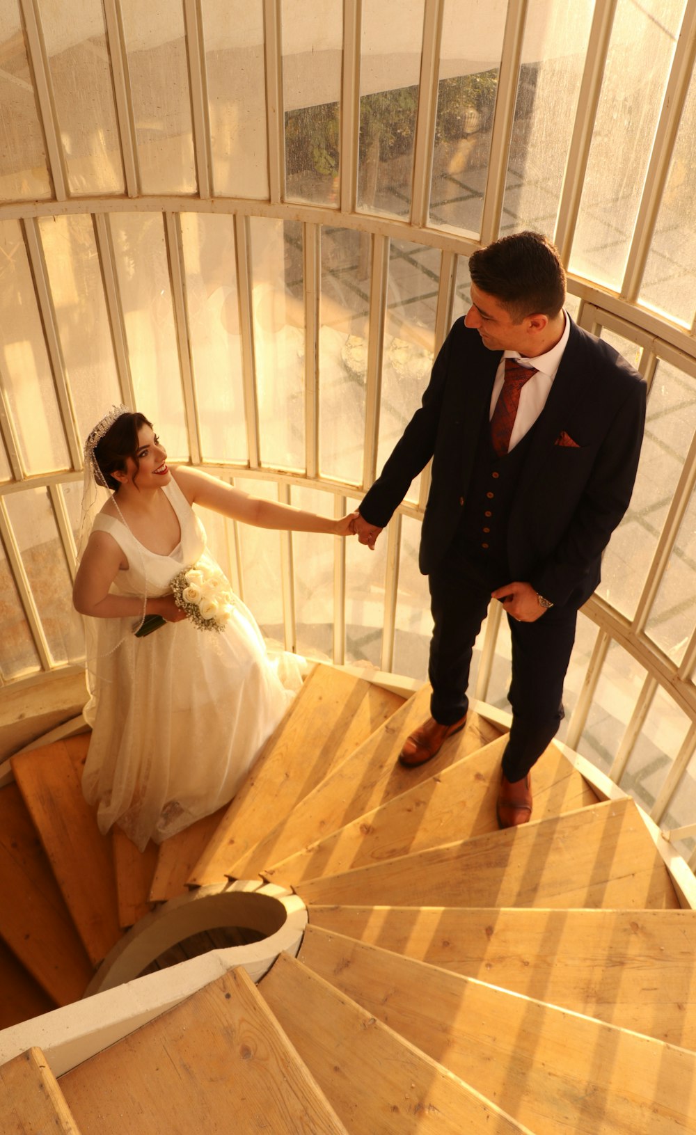 a bride and groom walking down a flight of stairs