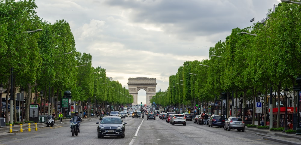 a street lined with cars and motorcycles next to the eiffel tower