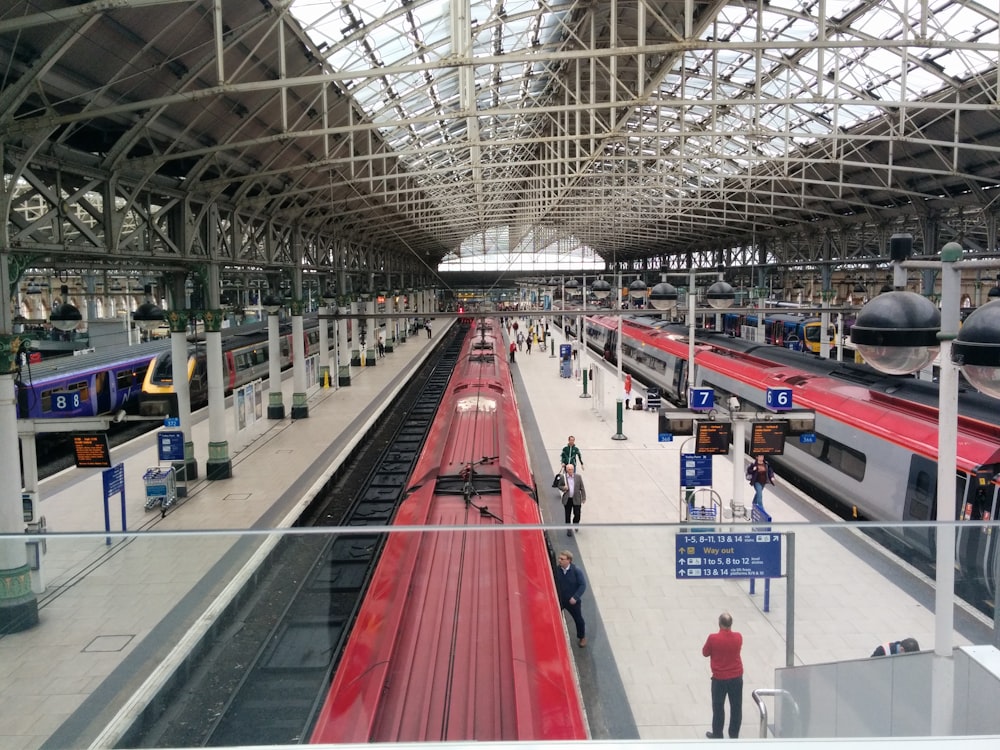 a train station filled with lots of red trains