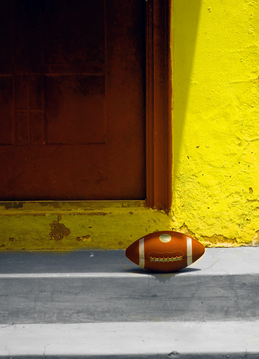 a football laying on the ground in front of a door