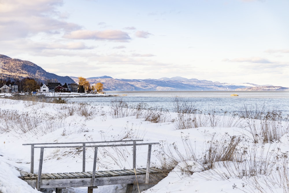 a bench sitting on top of a snow covered field