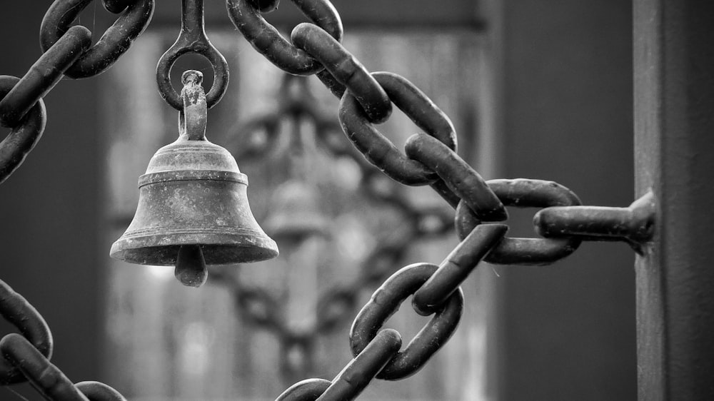 a chain link fence with a bell hanging from it