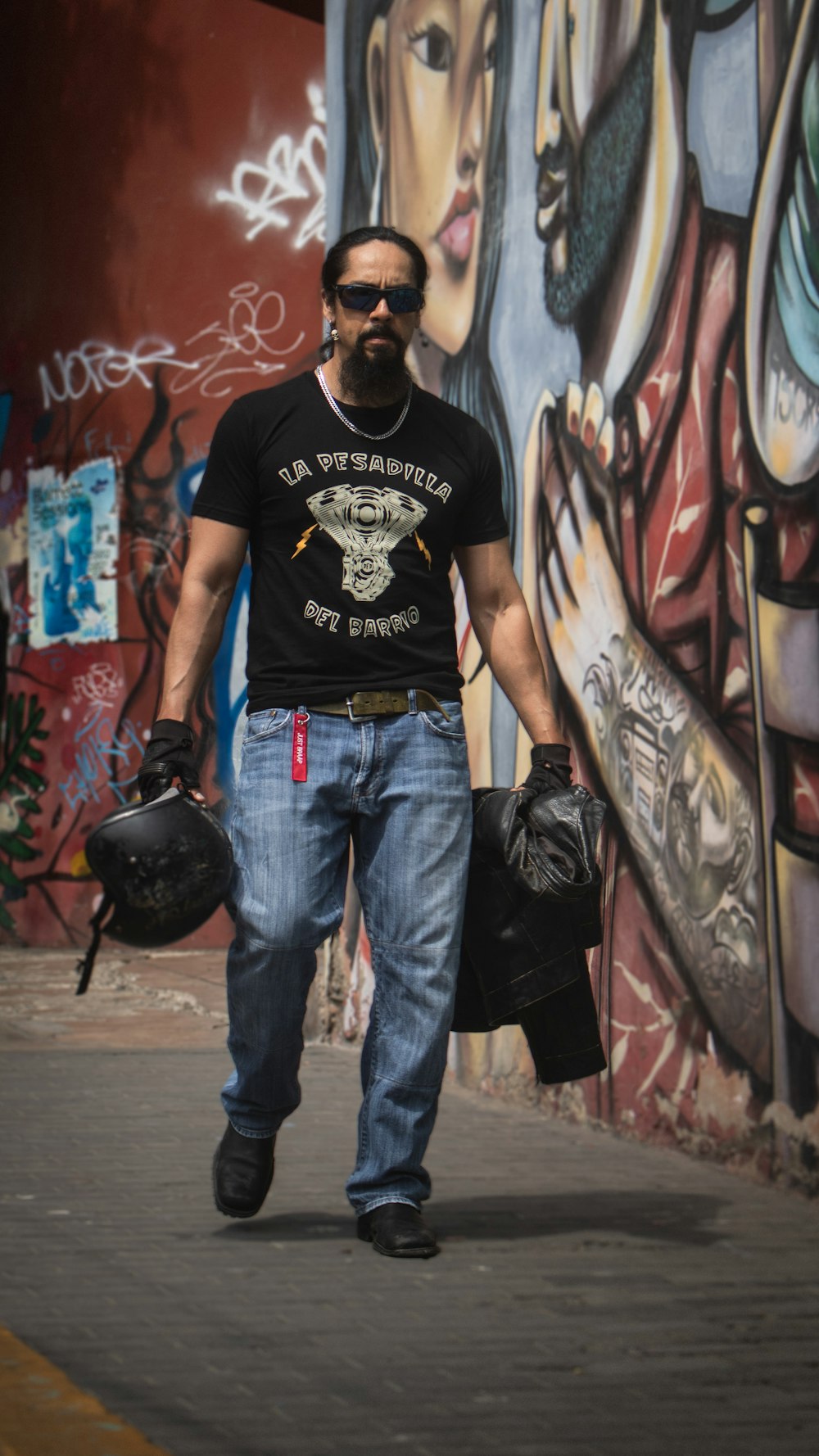 a man walking down a street with a motorcycle helmet