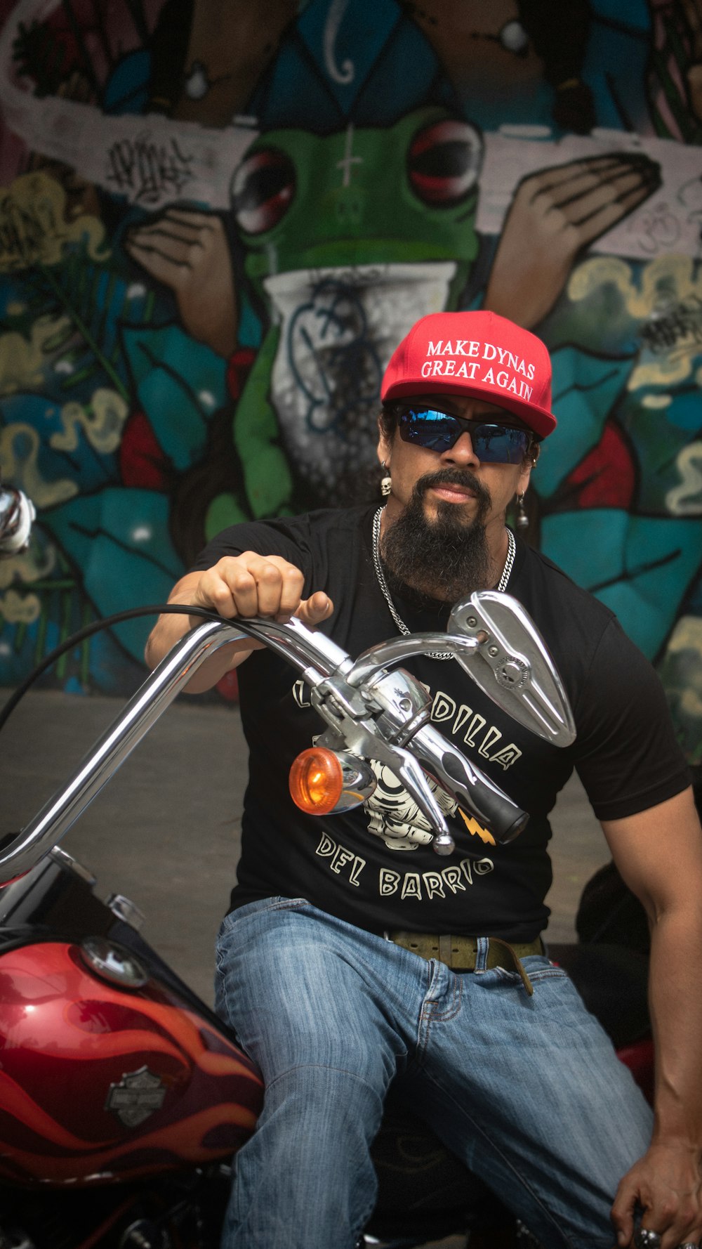 a man sitting on a motorcycle wearing a red hat