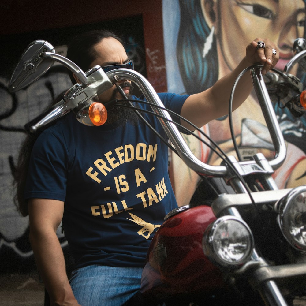 a man sitting on a motorcycle in front of a painting