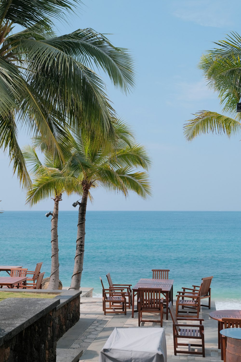 there are many chairs and tables on the beach