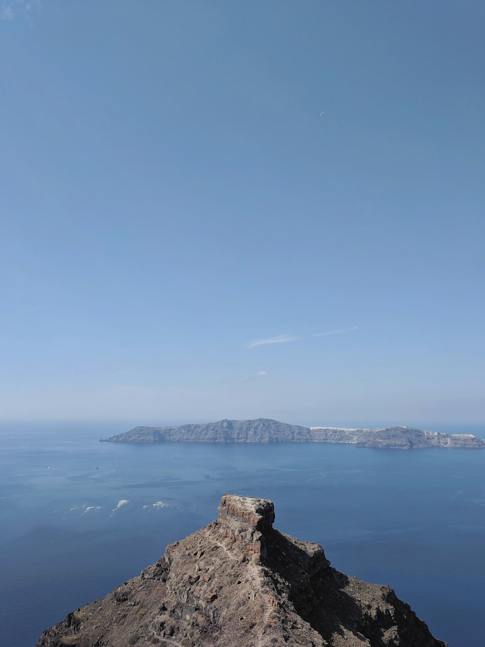 a bench sitting on top of a rock near the ocean