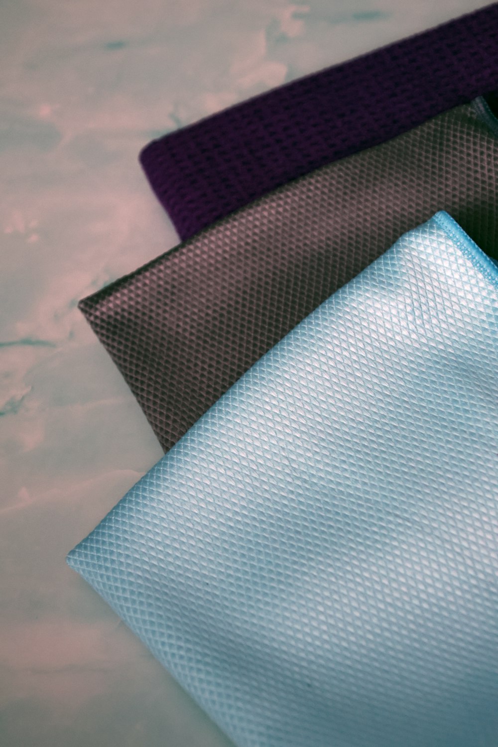 a close up of three different colored ties