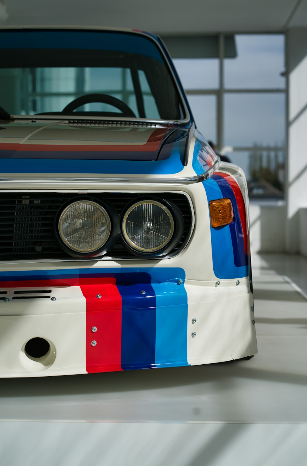 the front end of a car painted in colors of blue, red, and white
