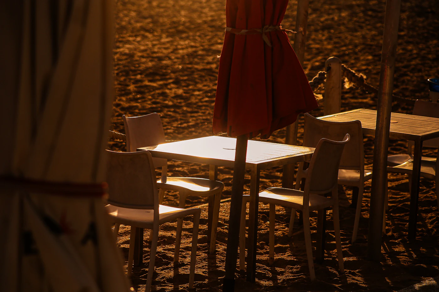 White table setting on the beach at golden hour
