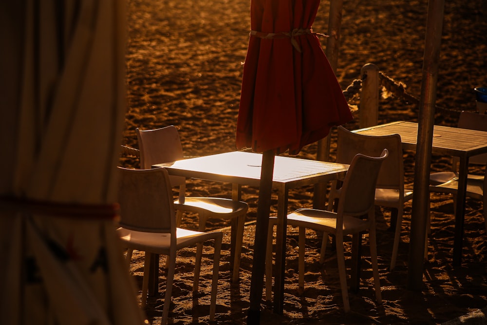 a table and chairs on a sandy beach