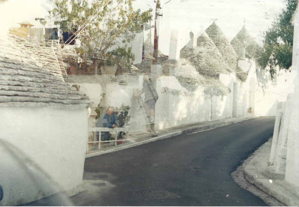 an old photo of a street lined with houses