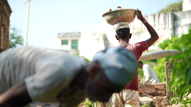 Indian construction worker carrying materials at a site