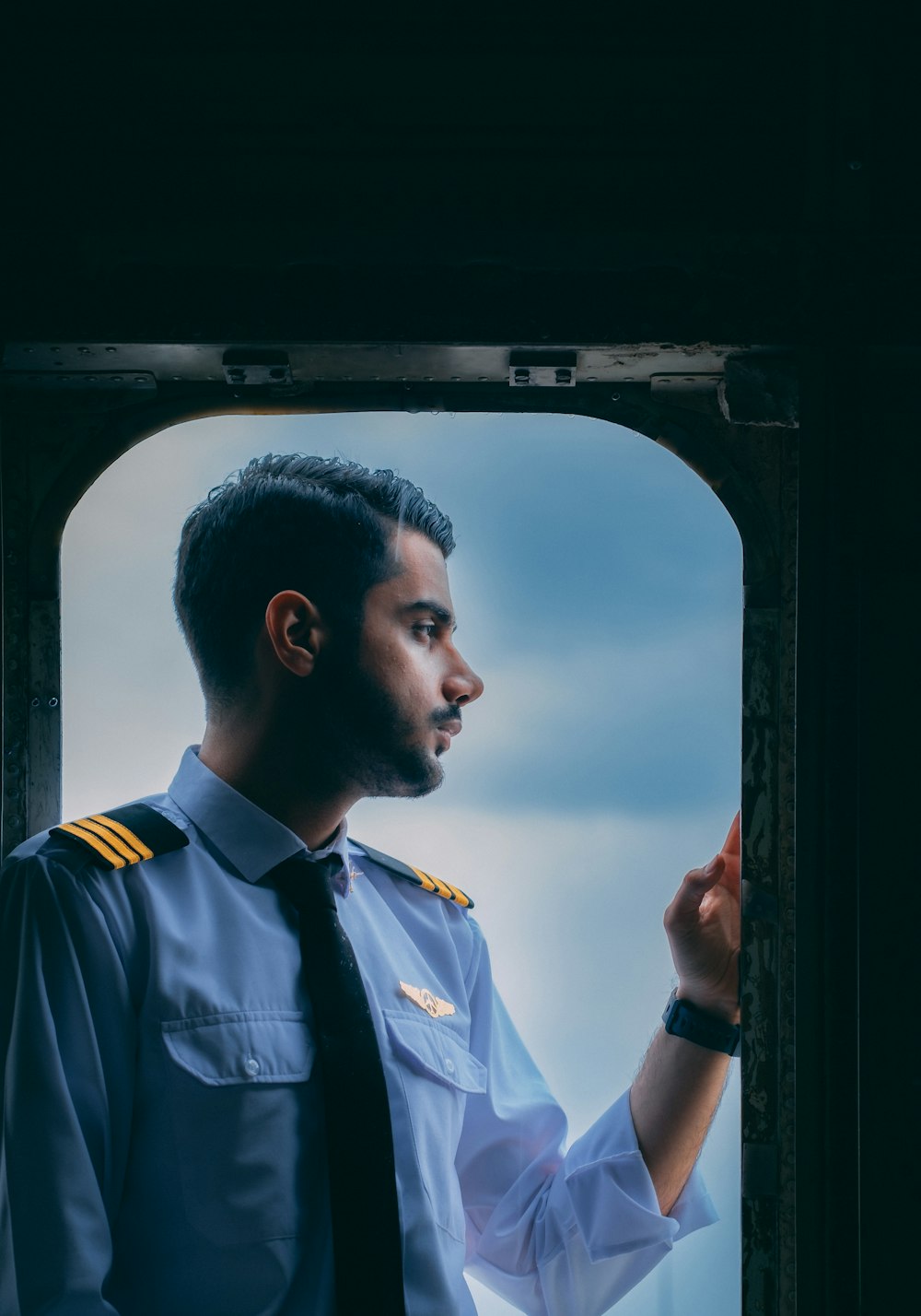 a man in a uniform standing in front of a window