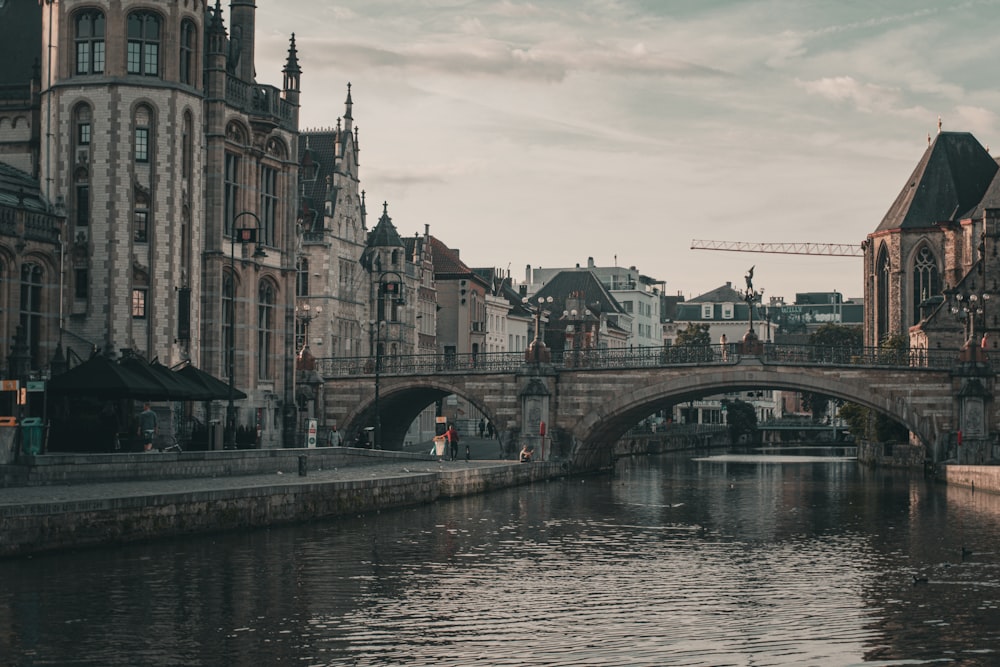 a bridge over a body of water with buildings in the background