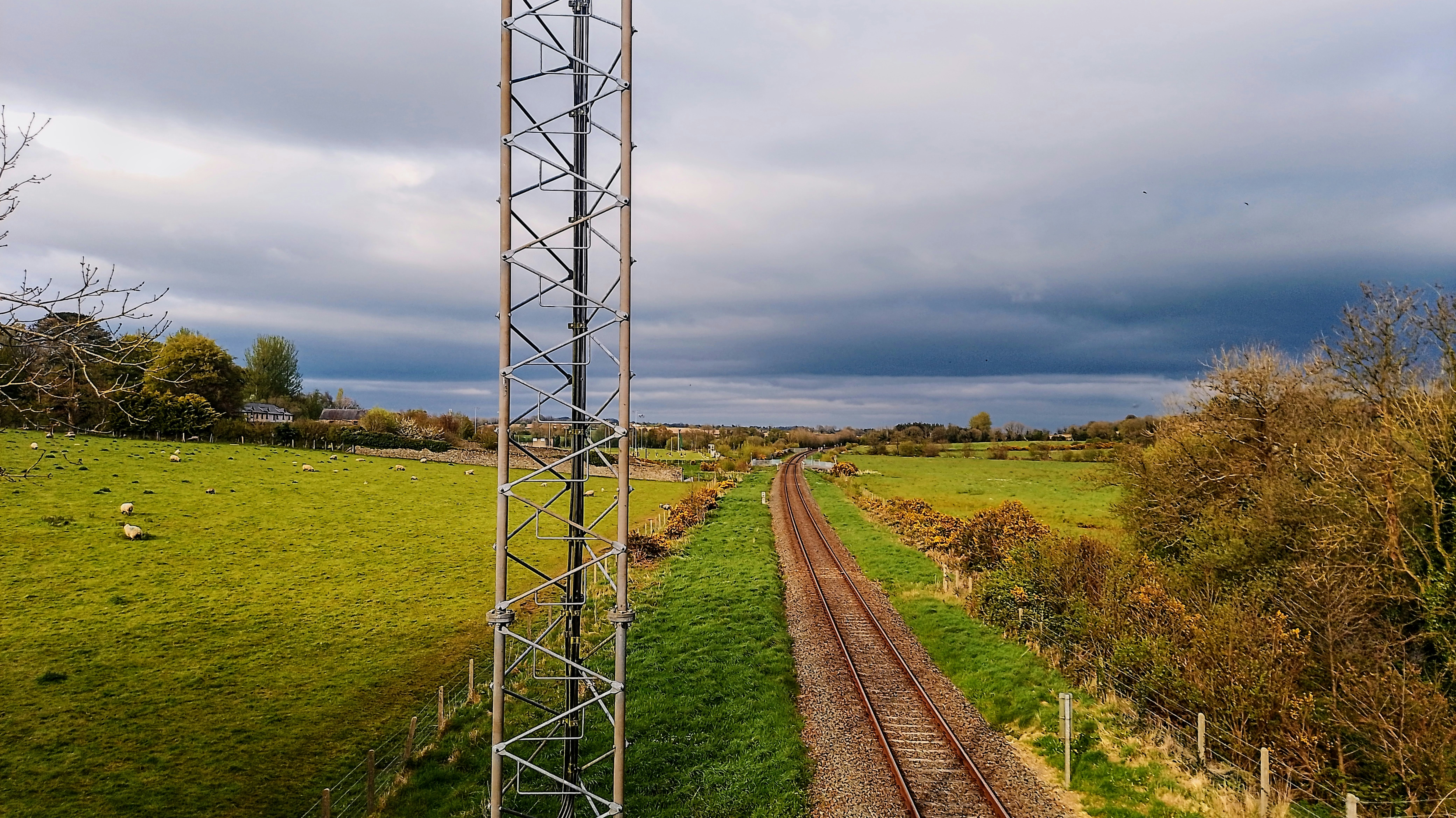 a train track running through a lush green field