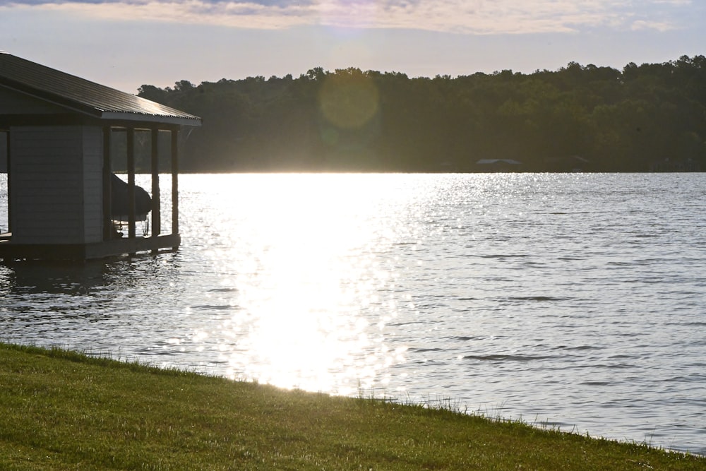 a boathouse sitting on the edge of a lake