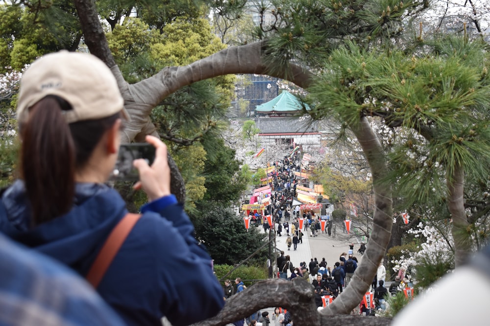 a woman taking a picture of a crowd of people