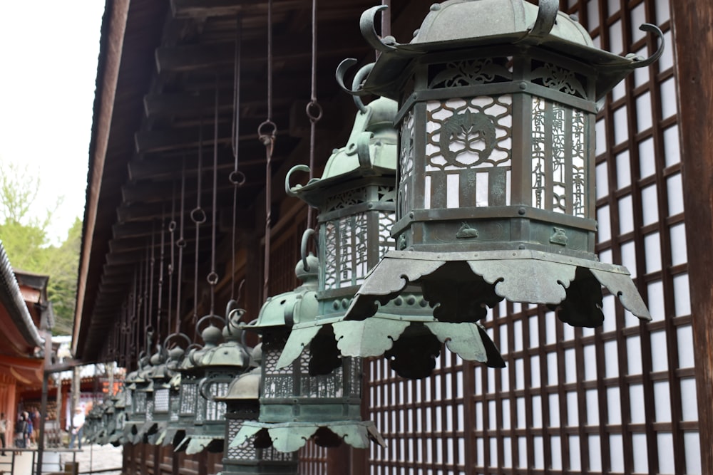 a group of metal lanterns hanging from the side of a building