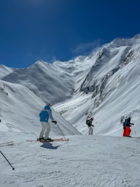 a group of people riding skis down a snow covered slope