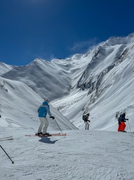 a group of people riding skis down a snow covered slope