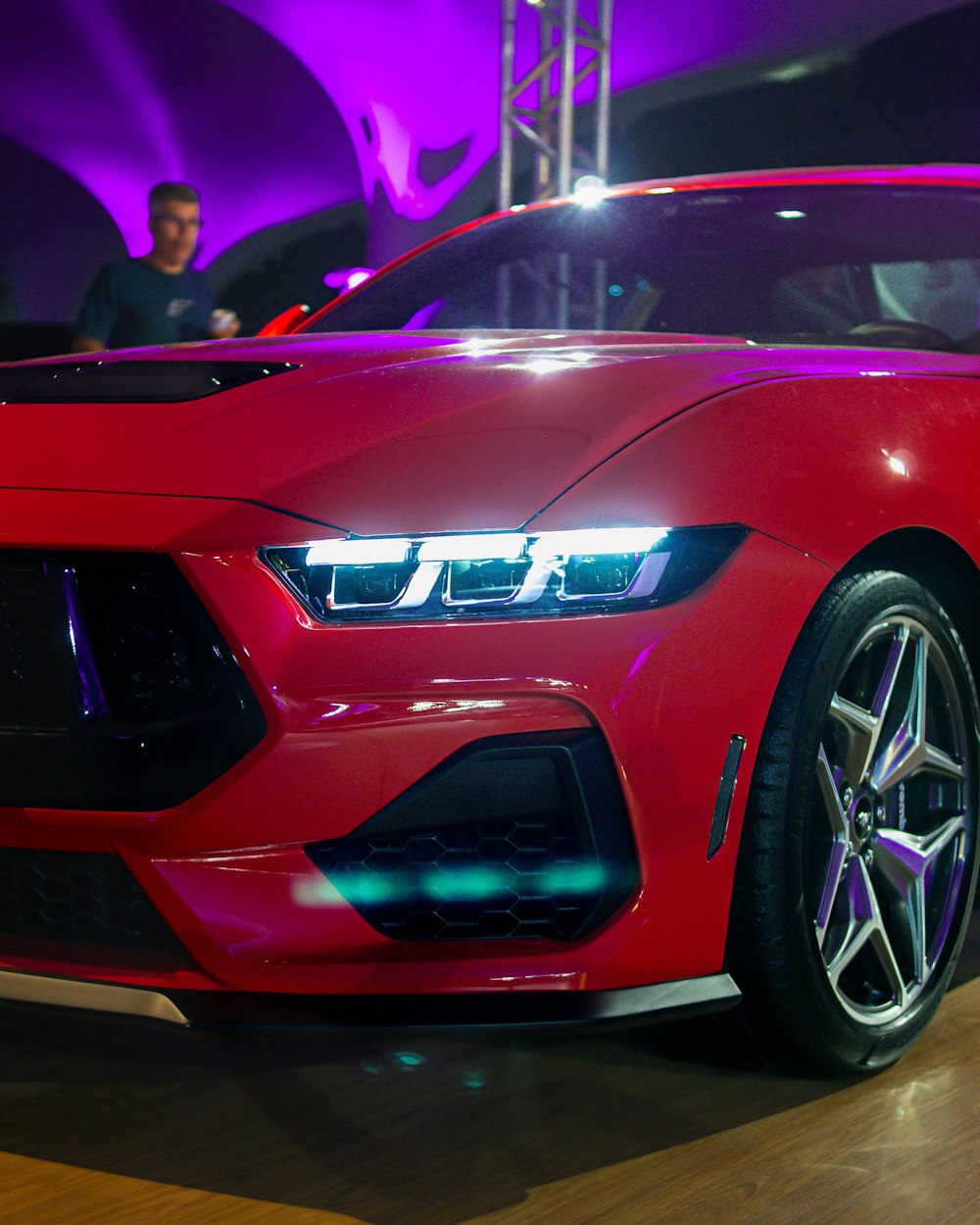 a red sports car on display at a car show