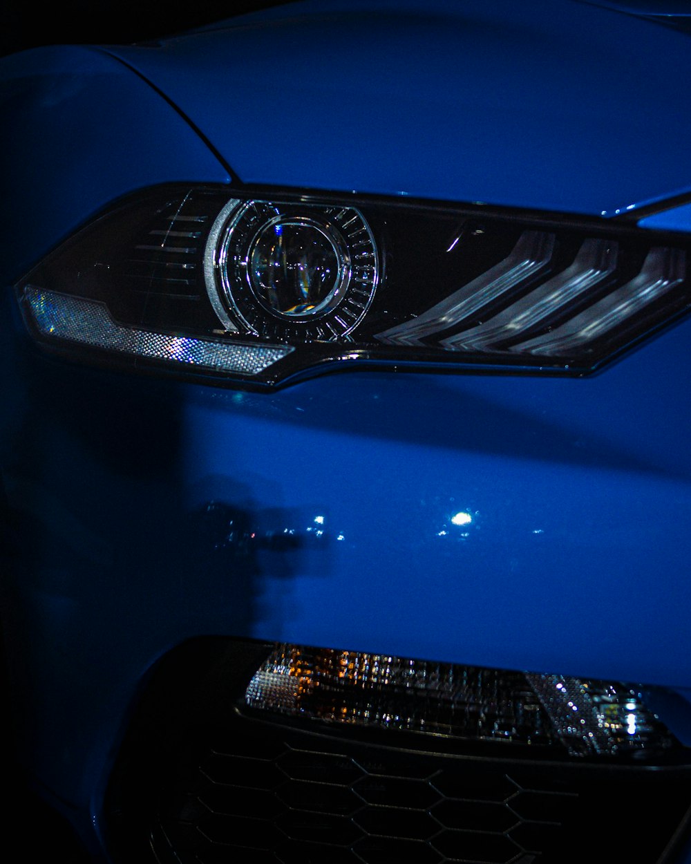 a close up of the front of a blue sports car