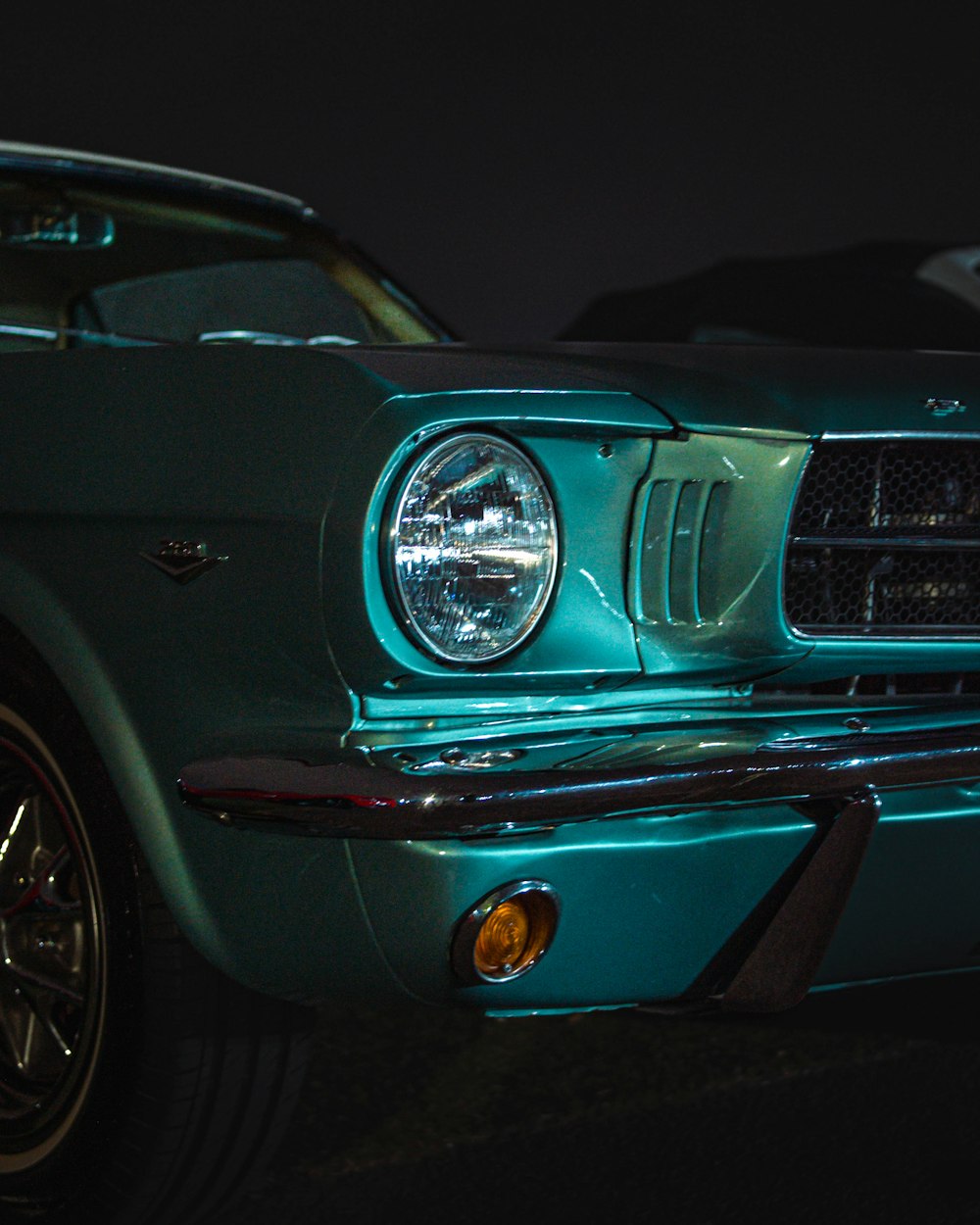 a close up of the front of a green mustang