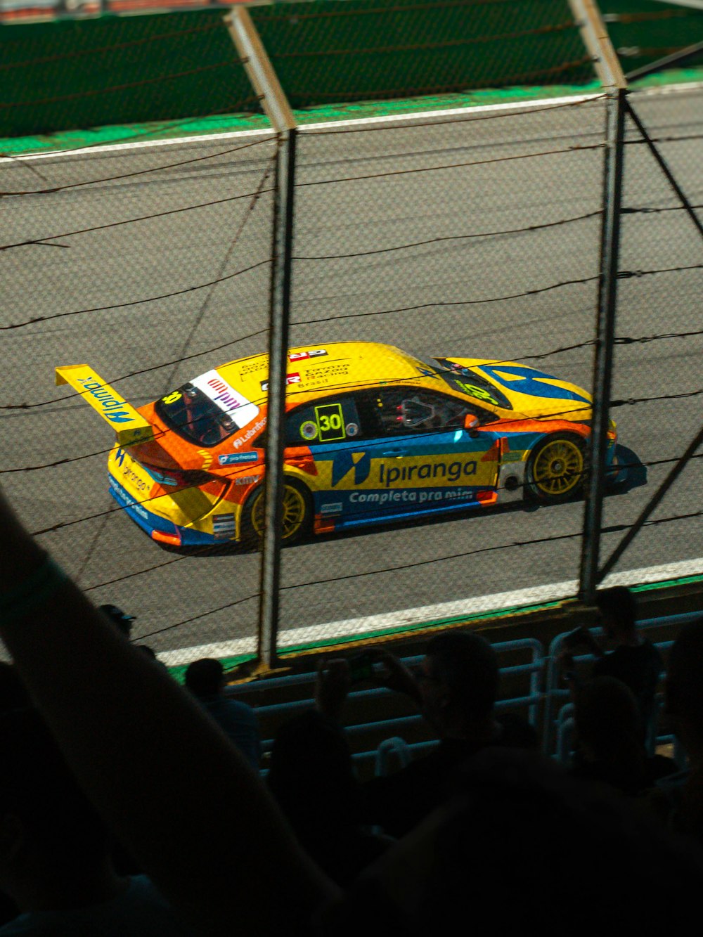 a yellow and blue car driving on a race track