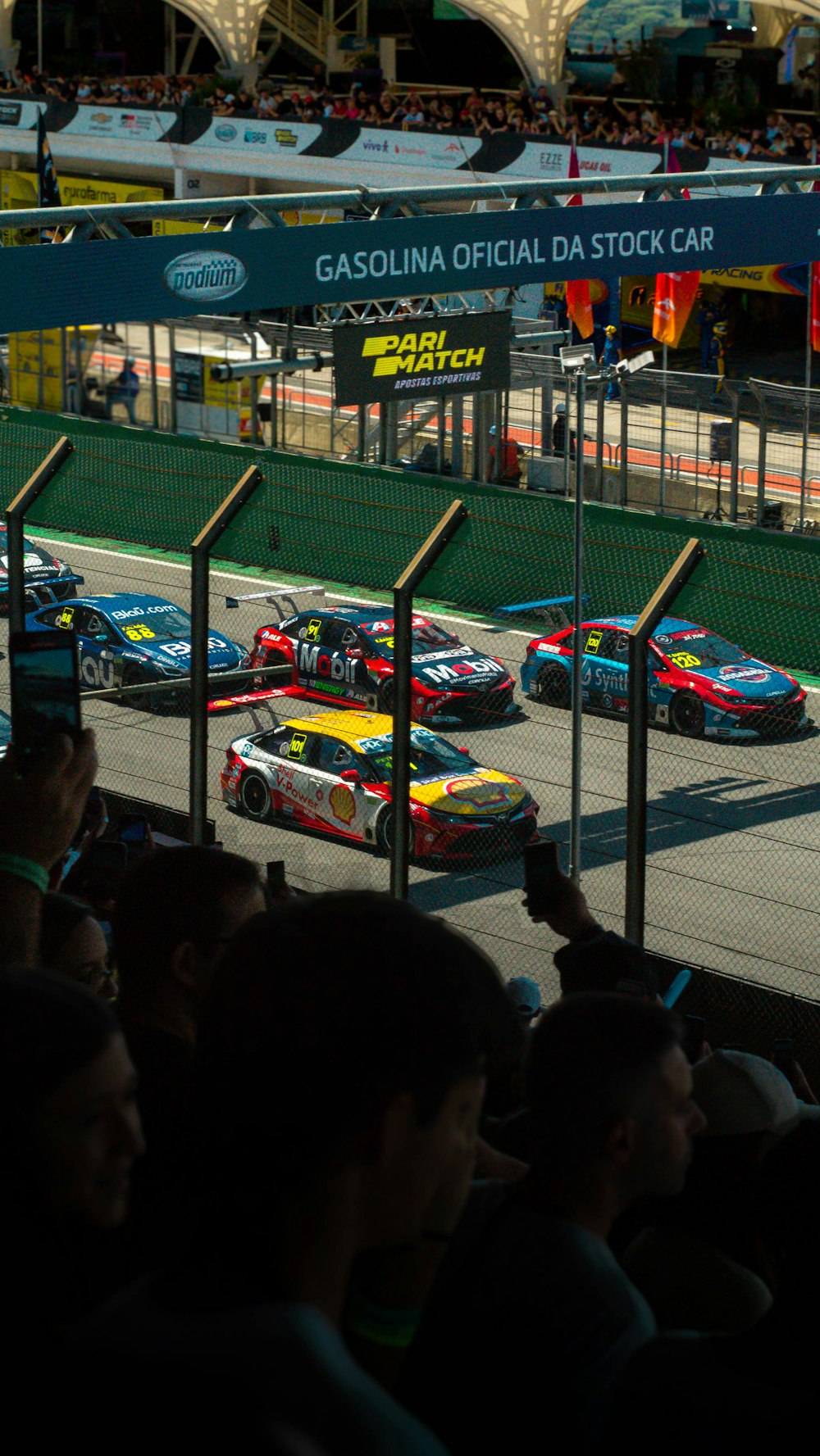 a group of cars driving down a race track