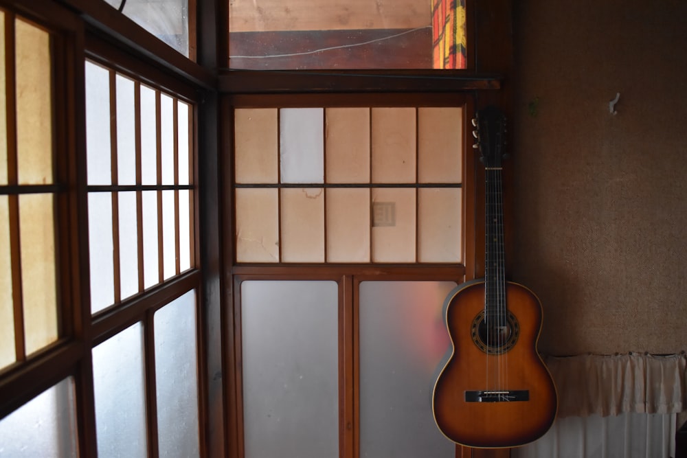 a guitar hanging from the side of a wall