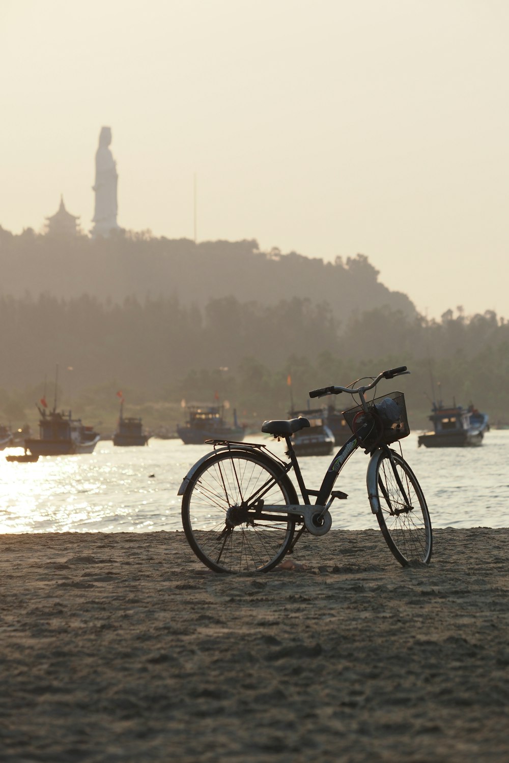 Una bicicleta estacionada en la playa cerca de un cuerpo de agua