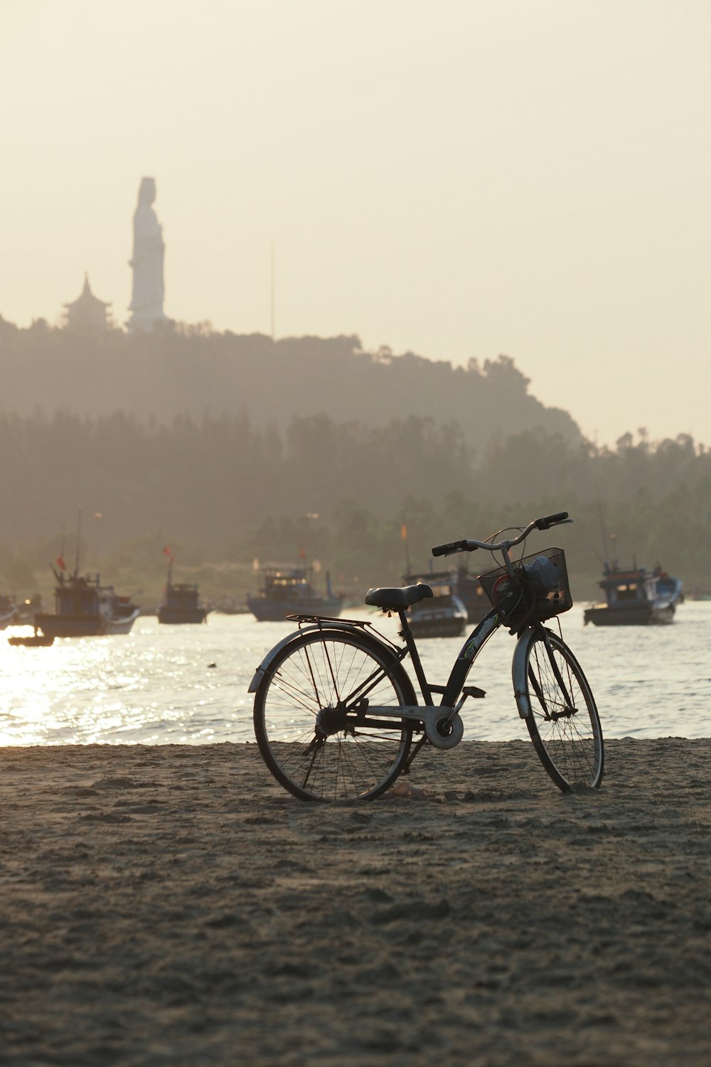 a bike parked on the beach near a body of water